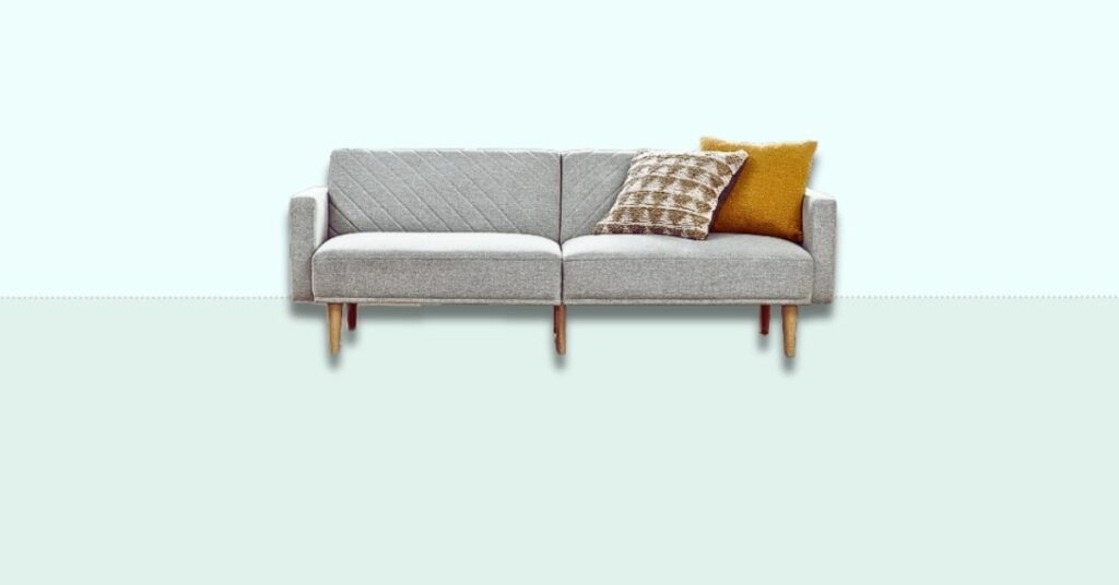 A grey couch with yellow pillows on it